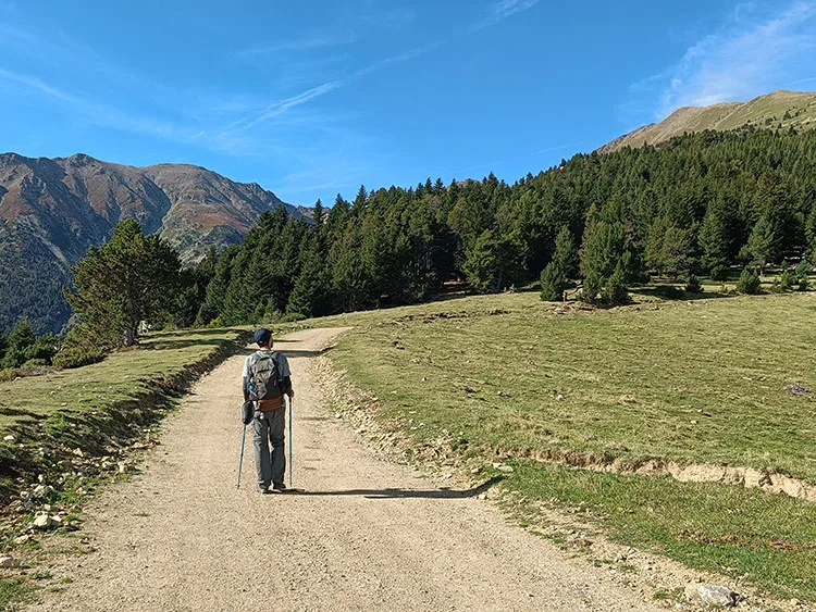 Cédric marche sur un sentier plat menant vers le refuge des Cortalets