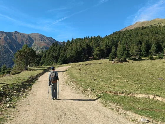 Cédric marche sur un sentier plat menant vers le refuge des Cortalets