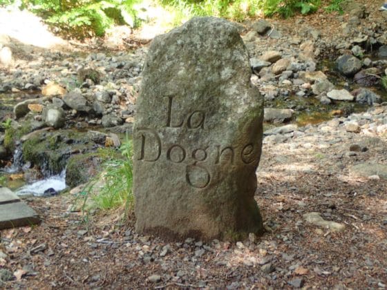 Borne indiquant "La Dogne", à côté d'un ruisseau
